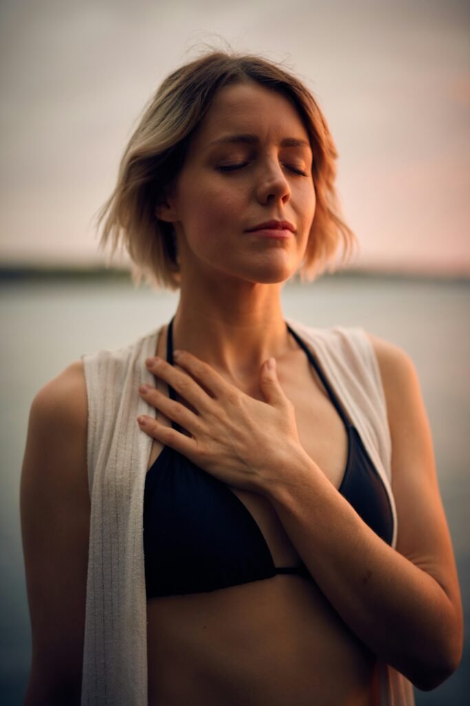 mujer con los ojos cerrados meditando con la mano en el pecho
